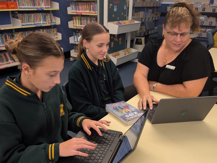 librarian with students on laptops