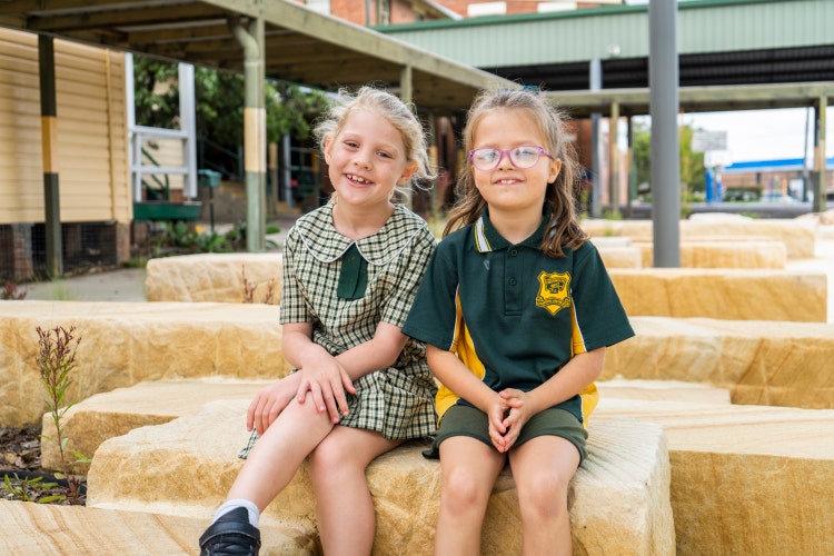 two students sitting in garden